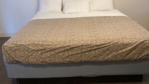 A neatly made bed with a patterned bedspread and two pillows. - Homestead Inn Extended Stay - 3 nights minimum (Wolf Point)