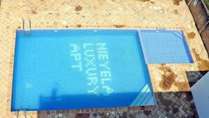 Ein rechteckiger Pool mit einer gefliesten Liegefläche.