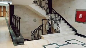 A marble staircase with ornate black railings leading to an upper floor. - Dar Alslama Apartment (Jeddah)