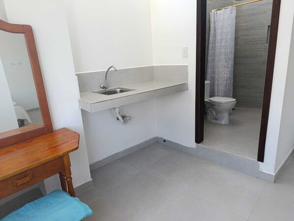 A bathroom with a wooden vanity, a sink, and a toilet.