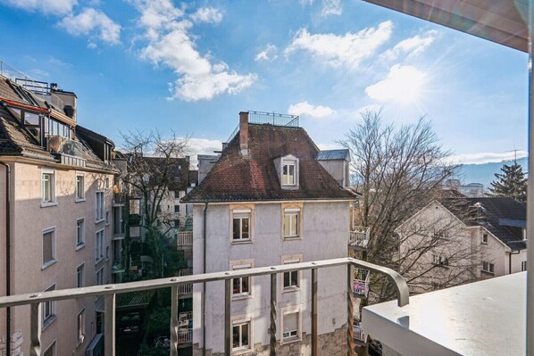 Ein Wohngebäude mit geneigtem Dach, mehreren Fenstern und einem Balkon.