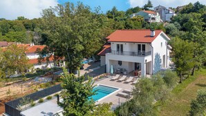 A modern two-story house with a swimming pool, surrounded by trees and other houses. - Villa Hidden with heated pool (Kvarner - Hlapa) (Hlapa)