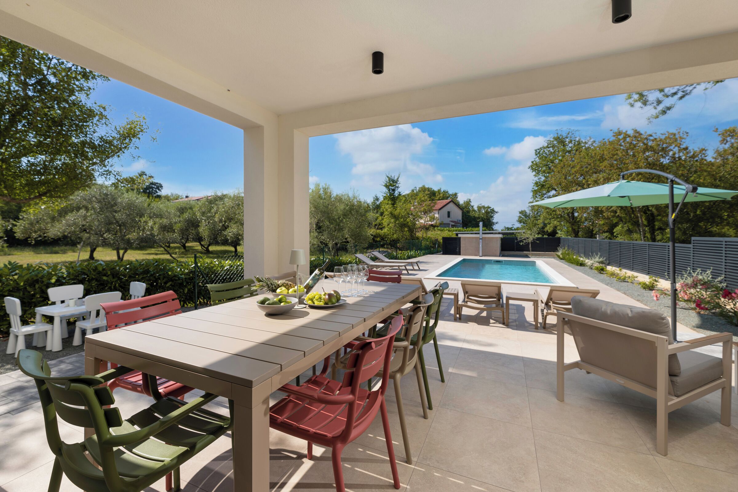 An outdoor patio with a pool, dining area, and lounge chairs.