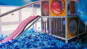 A children's play area with a slide, climbing structures, and a ball pit filled with blue balls. - Complete apartment at AquaLand Resort in Salinópolis – sleeps 4 (Salinópolis)