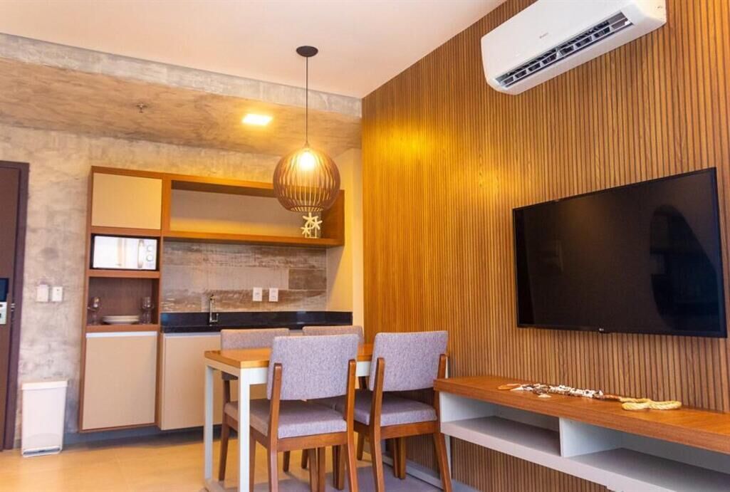 Eine moderne Küche mit Holzschränken, einem eingebauten Herd und einem Essbereich mit Tisch und Stühlen.