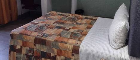 Un dormitorio con cama, escritorio y silla.