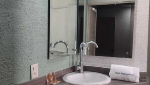 A bathroom with a white sink, a mirror, and a towel with "Hotel Metropolitan" on it. - Hotel Metropolitan (Guadalajara)