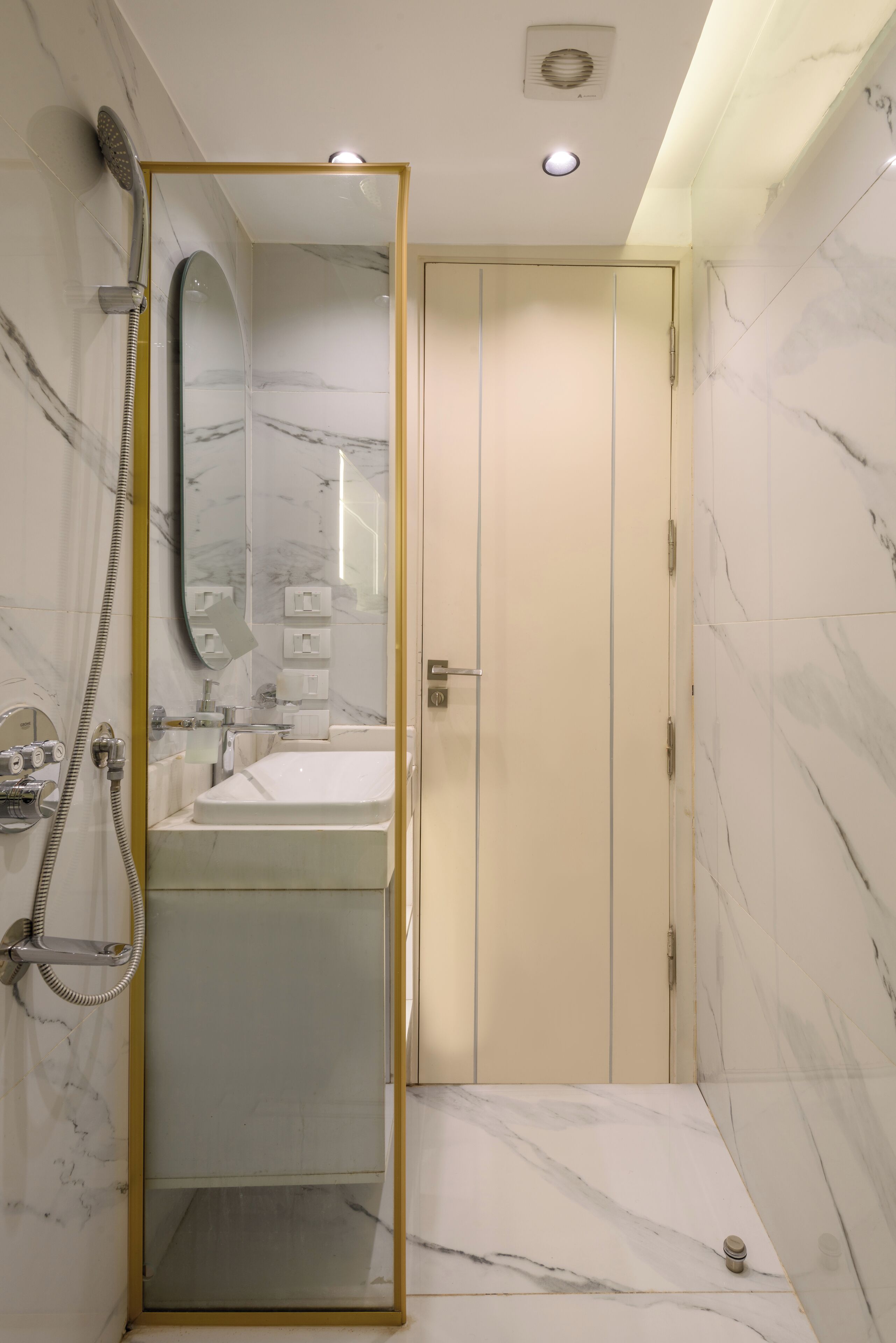 A modern bathroom with a walk-in shower, a large mirror, and a toilet.
