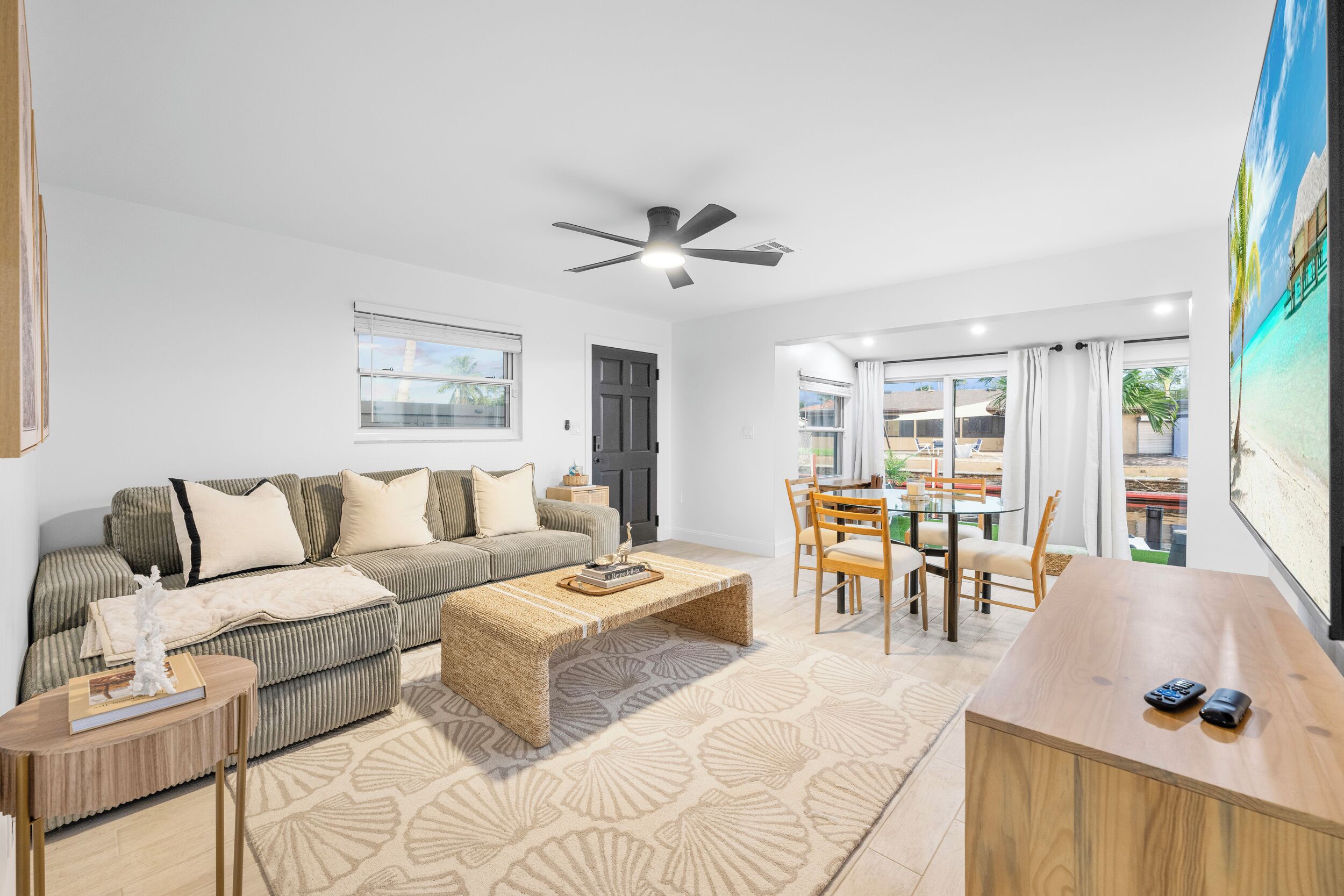 A modern living room with a sofa, coffee table, and dining area.