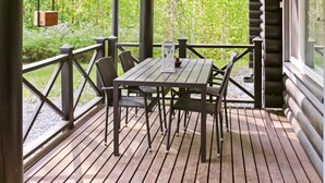 A wooden deck with a table and chairs, surrounded by a railing, overlooking a forested area. - Vacation home Siili by Interhome (Savonlinna)
