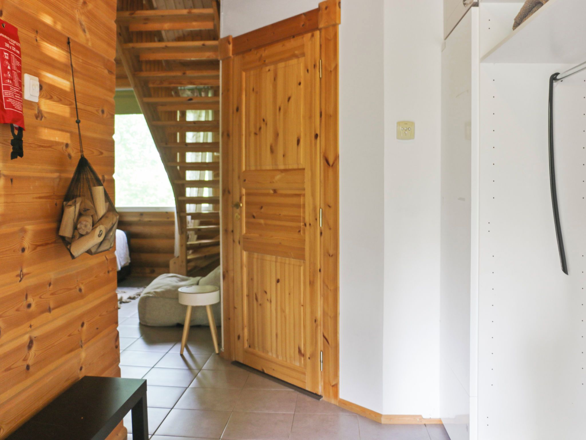 A wooden interior with a bench, a small table, and a door.