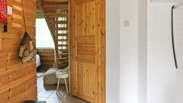 A wooden interior with a bench, a small table, and a door.
