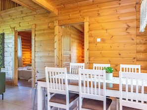A wooden interior with a dining table and chairs, a potted plant, and a view of the outside. - Vacation home Susi by Interhome (Savonlinna)