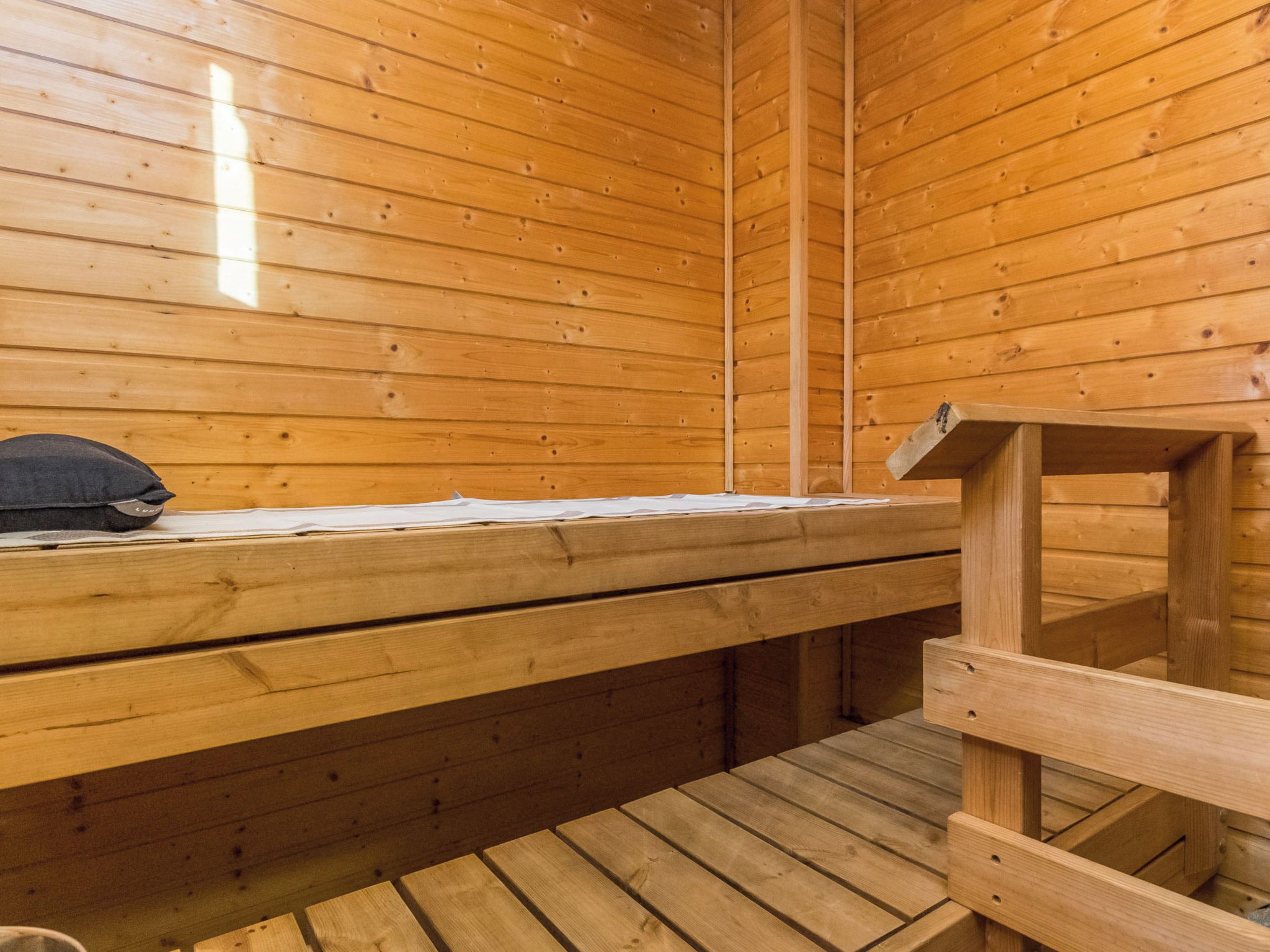 Un sauna de madera con bancos y un asiento de banco.