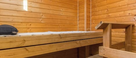 A wooden sauna room with benches and a bench seat.