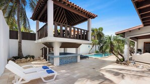 Ein Poolbereich mit Liegestühlen und einer überdachten Terrasse.