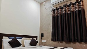 Habitación de hotel con cama, teléfono y aire acondicionado.
