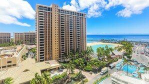 Un hôtel de grande hauteur doté de nombreux balcons, d’un espace piscine et offrant une vue sur la plage.