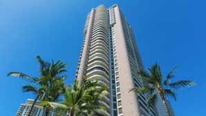 Un grand immeuble moderne, avec une façade incurvée et des balcons.