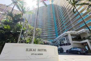 The Ilikai Hotel sign with a view of the building's exterior.