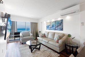 Un salon moderne avec un canapé, une table basse et un grand tableau.