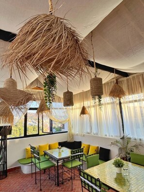A room with a green sofa, a small table, and hanging wicker lamps. - Mount Chaouen (Chefchaouen)