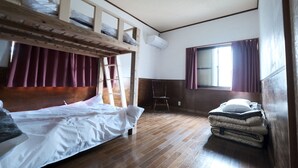 A room with a bunk bed, a chair, a window with curtains, and a radiator. - Guest House SAKURAZUKISOU - Hostel (Kagoshima)