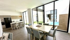 Una cocina moderna con comedor y ventanas amplias.