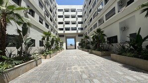 A multi-story building with a central courtyard. - Bright studio with balcony & sea view, near port (CASABLANCA)