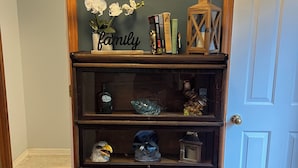Estante de madeira com objetos decorativos, um mapa de Tennessee e uma placa com a palavra 'família'.