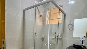 A modern bathroom with a glass-enclosed shower, a toilet, and a sink with a mirror. - Cozy house in Polvilho Cajamar, just a few minutes from Rod. Anhanguera (Jardim Santana Cajamar)