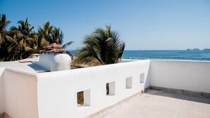 Un balcó blanc amb vista a l'oceà i palmeres.
