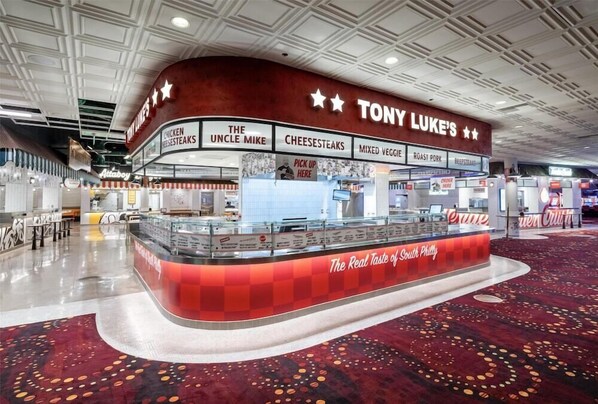 Un restaurant Tony Luke's avec un comptoir incurvé et une décoration aux couleurs rouge et blanche.
