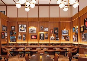 Un restaurante con paneles de madera, varias mesas y cabinas.