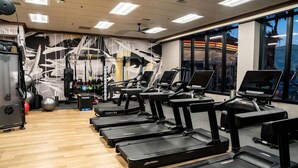 Ein Fitnessstudio mit Laufbändern, Übungsbällen und Krafttrainingsgeräten.