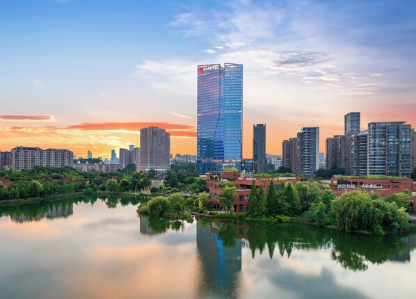 A cityscape with modern high-rise buildings, a calm lake reflecting the structures, and a mix of greenery and urban architecture. - Changsha Marriott Hotel West (Changsha)