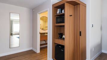 A modern kitchen with built-in appliances, a wooden cabinet, and a mirror.