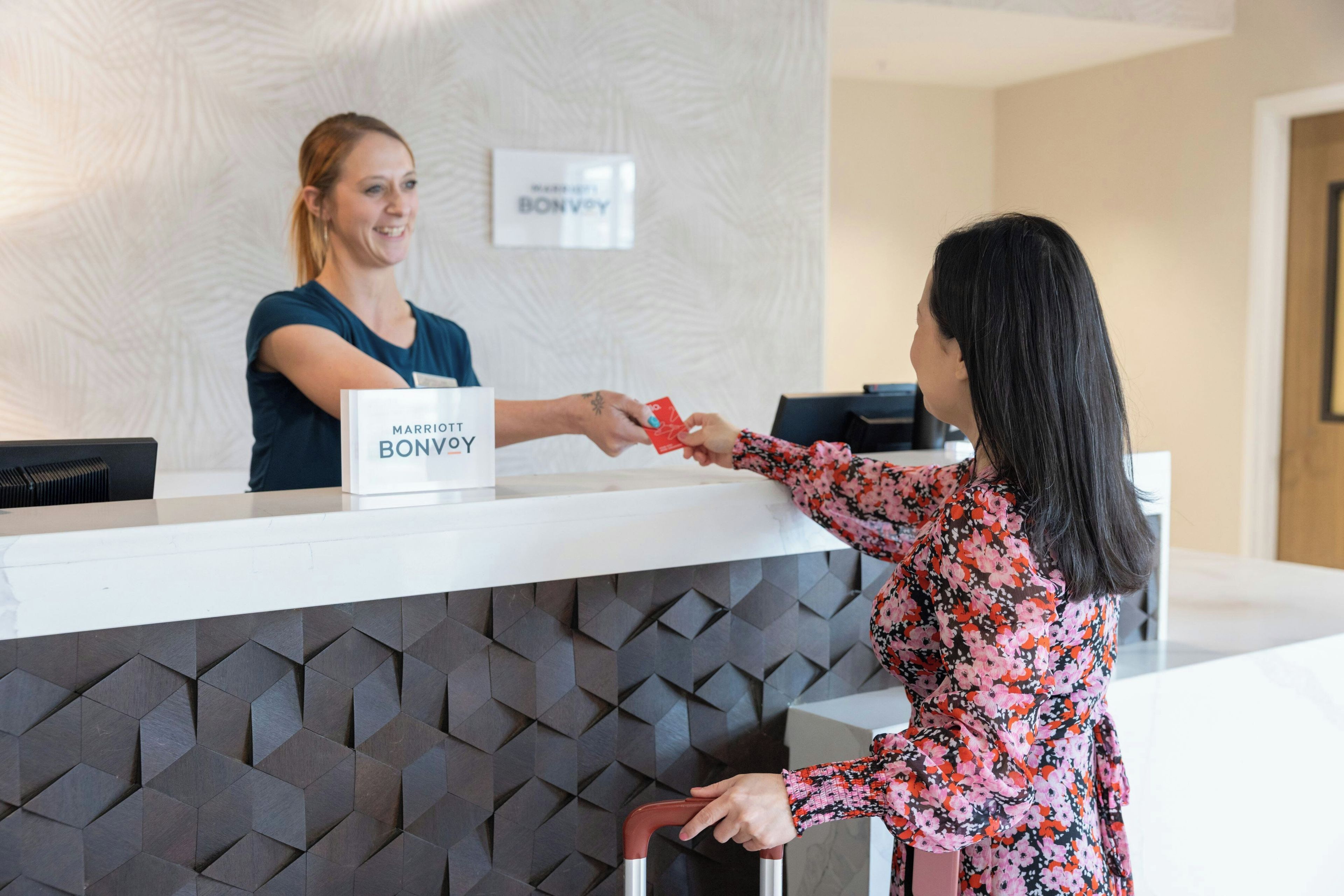 Una mesa de recepción de hotel con un cartel que dice 'MARRIOTT BONVOY'.