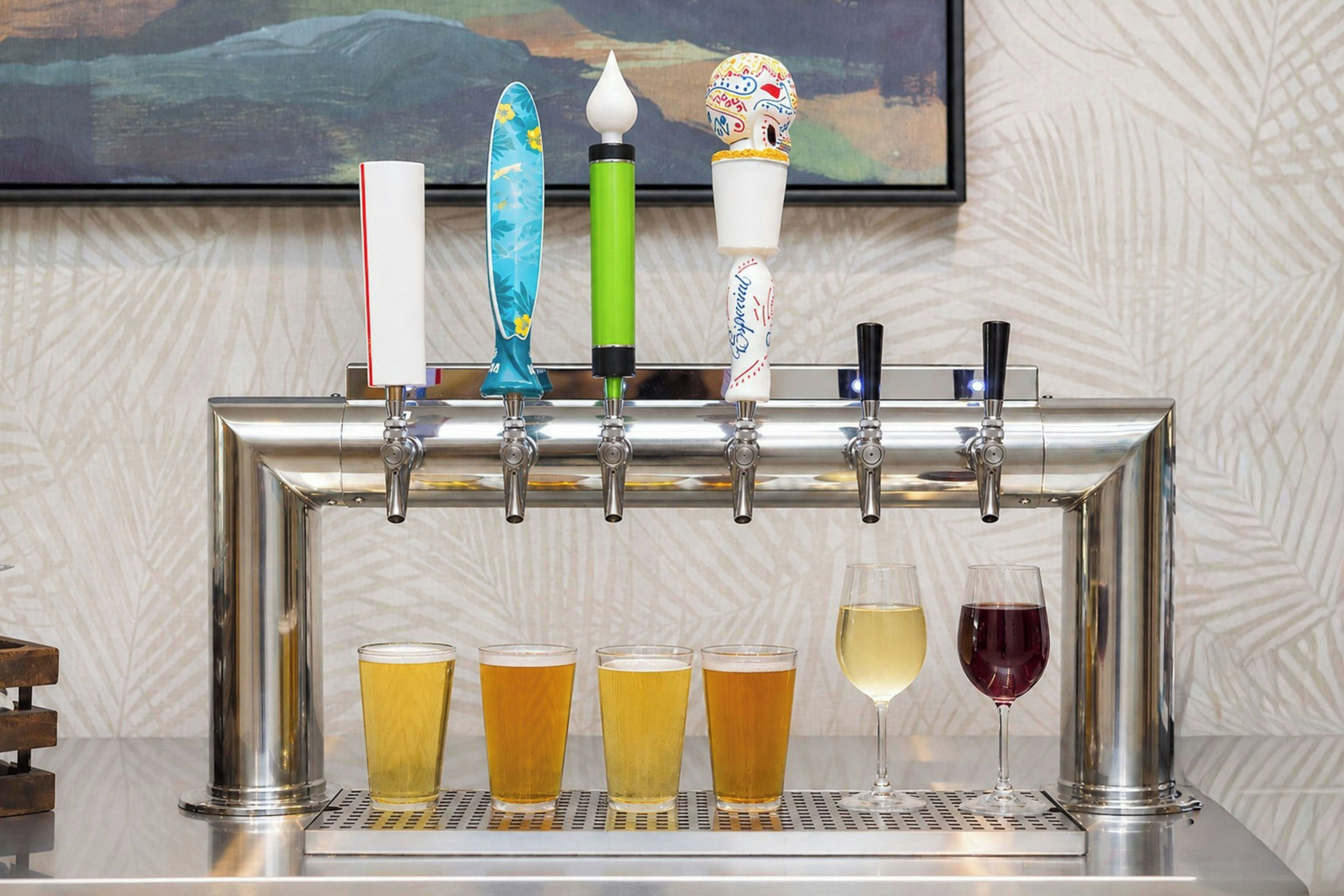 Un système de distribution avec plusieurs robinets et des verres à bière et à vin.