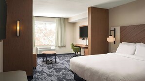 A hotel room with a large bed, a desk with a chair, a TV, and a window with curtains. - Fairfield Inn & Suites Huntsville Madison (Madison)