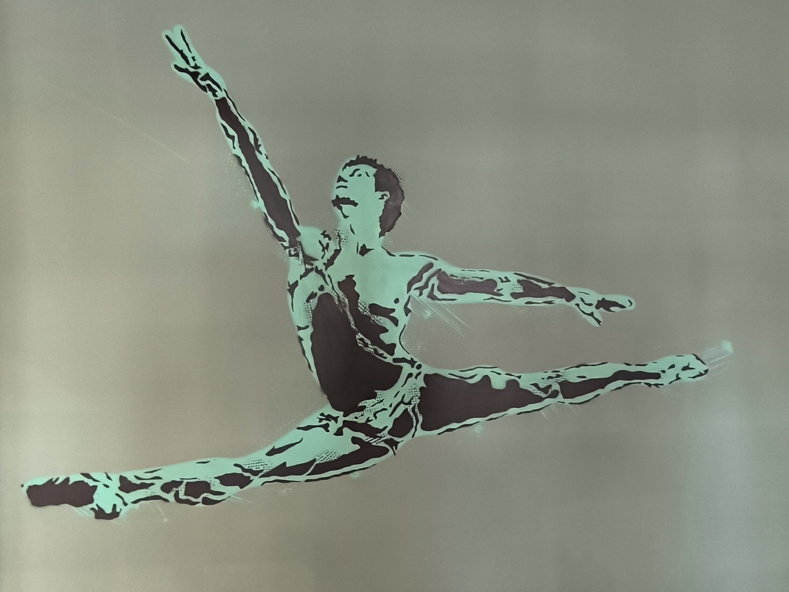 A dancer in mid-air with a blurred background.