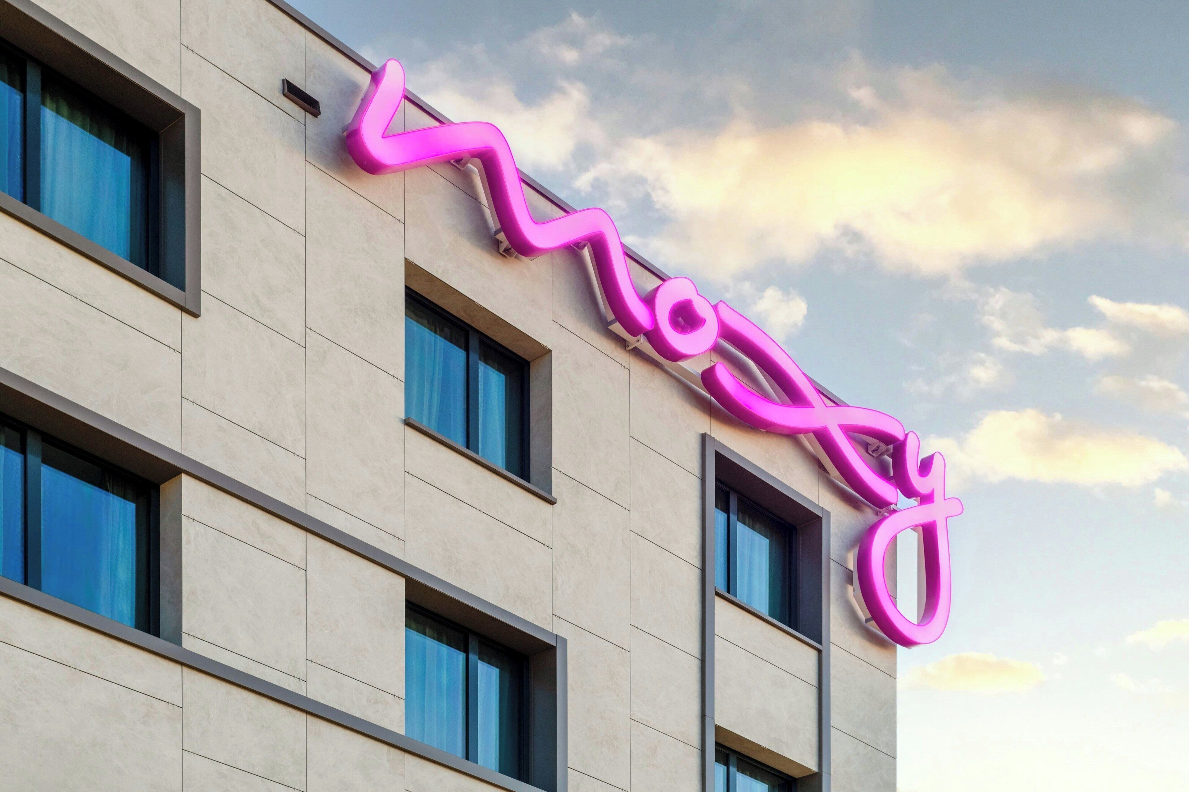 Un edificio con un letrero de neón rosa que dice 'Mogul' en la fachada.