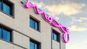 Un edificio con un letrero de neón rosa que dice 'Mogul' en la fachada.