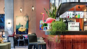 A bar area with a counter, a pink flamingo decoration, and a sign reading "CIAO VERONA". - Moxy Verona (Verona)
