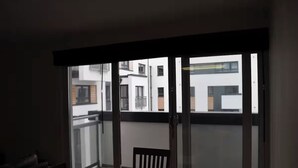 Ein Balkon mit Blick auf Gebäude, ein Stuhl und ein Tisch.