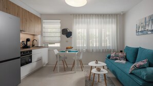 A modern kitchen with white cabinets, a black kettle, and a dining area with a white table and chairs. A teal sofa with patterned cushions is in the living area, and a painting of sailboats is on the wall. - Modern Studio Apartman 1 Desamani 975, Kostrena, Croatia (Kostrena)