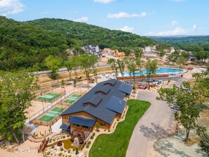 A large house with a water wheel, tennis courts, and a swimming pool. - Private Hot Tub Cabin Near Table Rock with Free Tickets & Indoor/Outdoor Community Pools (Hollister)