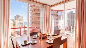 A dining area with a table set for two, a bottle of water, and a fruit bowl. - Benidorm Levante Beach 11A, Benidorm, Spain (Benidorm)