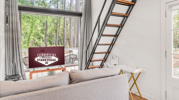 Ett modernt vardagsrum med en soffa, en stege och en välkomstskylt för Starkvegas.