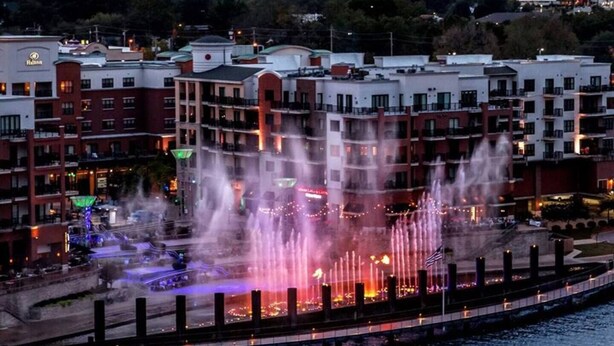 A hotel with multiple stories, a waterfront location, and a fountain display. - Branson Fun Zone | Dog-Friendly • Games • Pool (Branson)